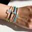 This picture shows a bracelet stack with the black enamel bangle and other items.