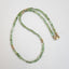 A square faceted green tourmaline beaded necklace with gold beaded accents and lobster clasp. 