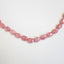 Product picture showing a naturally pink colored gemstone necklace finished with 14k gold findings and clasp. The necklace is hand knotted with pink colored silk string.