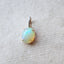 Product picture of opal pendant with a cabochon opal set with four prongs and a diamond bail. 14k solid gold.