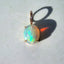 Product picture of opal pendant with a cabochon opal set with four prongs and a diamond bail. 14k solid gold.