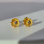 A pair of solid gold daisy earring with dainty pedals and a diamond center. 