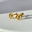 A pair of solid gold daisy earring with dainty pedals and a diamond center. 