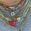 Showing a necklace layering of necklaces and emerald padlock. This padlock has a center emerald and diamond on top and bottom.