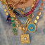 Featuring an example picture wearing the green hamsa, in a necklace layering. 