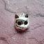 A product picture of a silver cat mast pendant. This charm is a mask of a cat made in 3d with round cute cat face and pointy ears. 