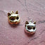 A product picture of a solid gold cat mast pendant. This charm is a mask of a cat made in 3d with round cute cat face and pointy ears. 