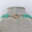 A strand of blue amazonite gemstone necklace with gold bead spacer between each stone. Finished with a wheel clasp.